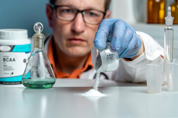 Sport Nutrition Supplement in lab. Doctor examines BCAA powder.