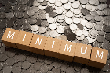 ミニマム・最小限のイメージ｜「MINIMUM」と書かれた積み木とコイン