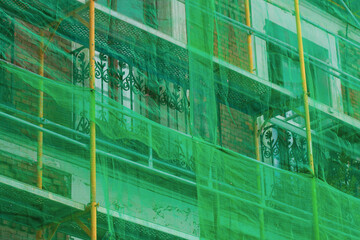 Protective facade netting mesh for scaffolding, building grid covers the facade of an old historic...