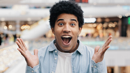 Male portrait emotions enthusiastic surprised shocked amazed man african american guy teenager looking at camera opens mouth and eyes in surprise delight winning victory luck success discount offer - obrazy, fototapety, plakaty