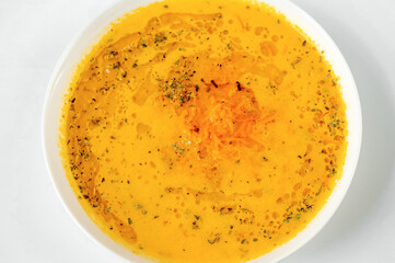 Closeup carrot soup in white plate.