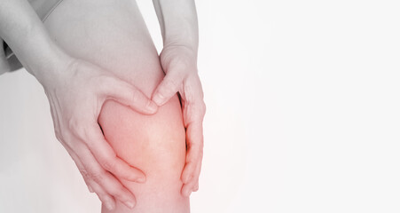 Woman use both hand clamp her knee wo express pain and ache of rheumatoid or tendon disease