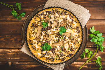 Vegetarian mushroom tart with parsley on wooden table