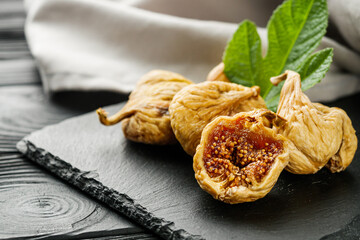 delicious dried figs on a black rustic wooden background