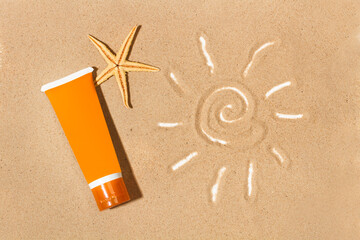 Botella tubo de crema de protector solar de color naranja sobre un fondo de arena junto a un dibujo de un sol. Vista superior y de cerca. Copy space
 - obrazy, fototapety, plakaty