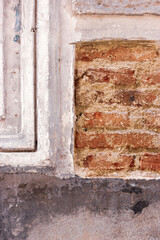 Brick texture for the background. A shabby facade of an old red brick building. A dilapidated house...