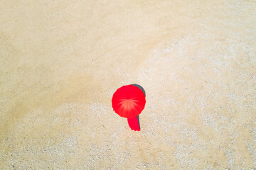 Woman with red umbrella walking on dry yellow desert ground. Hope concept. Aerial, top view.