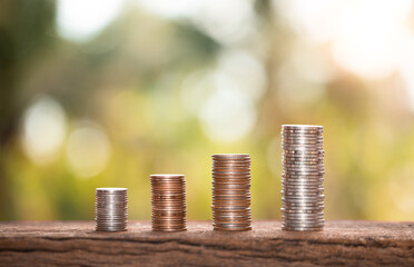 a pile of coins on a wooden table with natural bokeh background, for saving money wealth, financial...