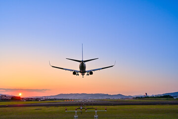 美しいマジックアワーに伊丹空港に着陸する飛行機