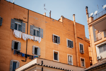 Fototapeta na wymiar Italian house with windows with shutters and laundry drying on the rope under the windows