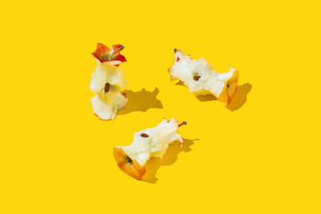 Apple stubs on on yellow background. Healthy eaten and diet concept. - obrazy, fototapety, plakaty