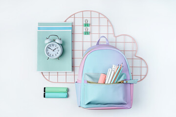 Grid wall organizer with stationery and backpack on white background. School stationery or office...