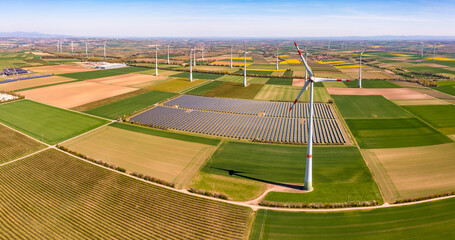 Solar panels next to wind turbines between agricultural fields, Germany
