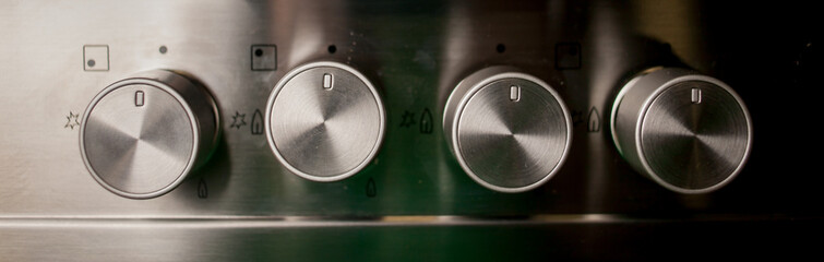 Metallic switch on the electric stove close-up. Closeup Of Knobs Switch Of Gas Stove. Control knobs...