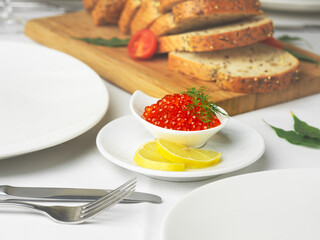 red fish salmon caviar served on wooden desk with salt, bread and lemon 