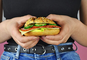 A healthy lunch, a girl holds a sandwich made at home ...