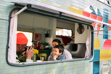 An outside view of a multicultural family photographing in a van.