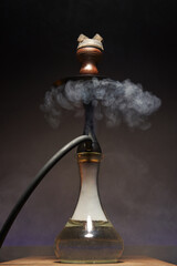 beautiful hookah with a transparent flask in a cloud of white smoke