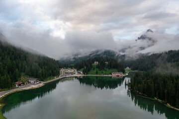 Fototapeta na wymiar Panorama drone view of Lago di Misurina, reflection of the mountain in the lake, flying through the fog in the Dolomites in Italy