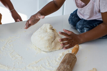 Girl kneading dough in kitchen