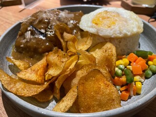 White rice with beef, chicken, egg and potato chips balado with black pepper seasoning plus green beans served in a large bowl.