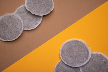 Top view of coffee pads on orange and brown cardboard at 45 degree angle . Flat Lay composition