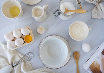 Fototapeta na wymiar Huevos, azúcar, leche, harina, preparación, receta, pastel, ingredientes, cocinar, mármol, pastelería.
