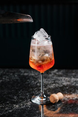 adding ice in aperol spritz. preparing cocktail in a bar