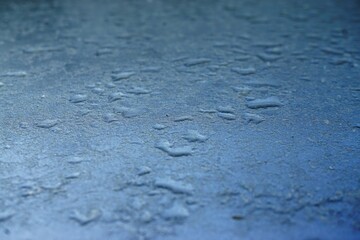 Blau-graue Metallfläche mit Regentropfen 