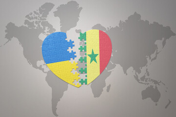 puzzle heart with the national flag of ukraine and senegal on a world map background. Concept.