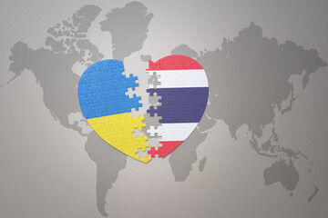 puzzle heart with the national flag of ukraine and thailand on a world map background. Concept.