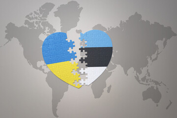 puzzle heart with the national flag of ukraine and estonia on a world map background. Concept.