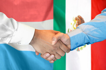 Handshake on Luxembourg and Mexico flag background. Support concept