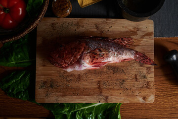 Raw sea bass fish on a cutting board. Preparing a Healthy Dinner