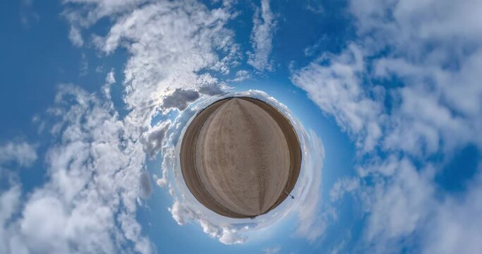 abstract folding of tiny planet in blue sky with clouds. Little planet transformation with curvature of space with loop rotate