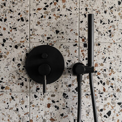 Shower tap in wall with terrazzo tiles