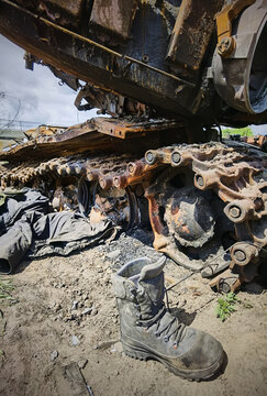 Kyiv region, Ukraine - May 15, 2022: War in Ukraine. Highway Kyiv - Zhytomyr. People take selfies against destroyed russian tank after russian atack in Febrary.