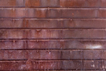 Rusted metal wall texture or oxidized metal fence background with horizontal metal rusty tiles