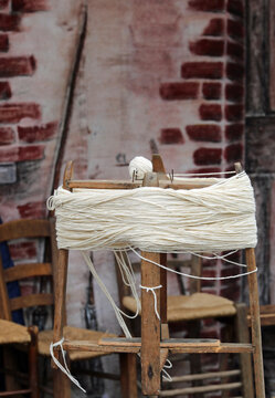 wooden spinning wheel to create balls of wool by spinning the skein of yarn in the old rural country house
