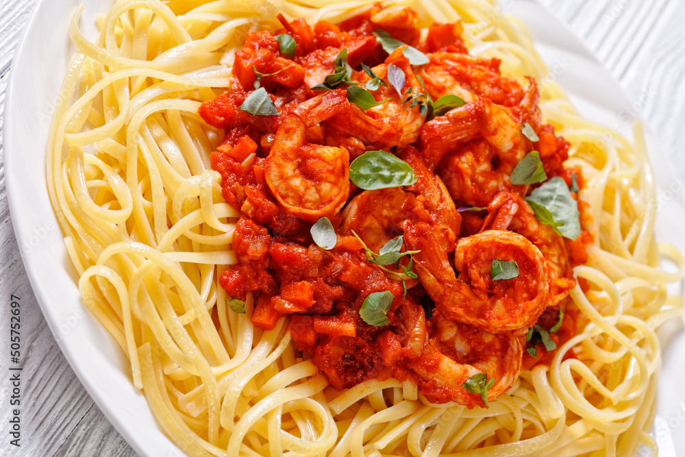 Sticker prawns in tomato sauce with noodles, top view