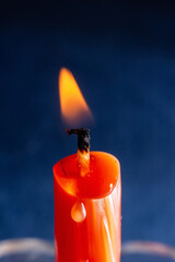 a small orange candle burns on a blue background