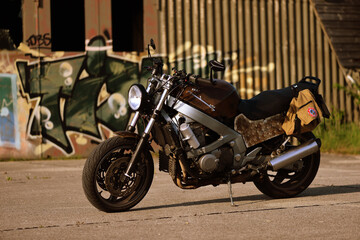 Fototapeta na wymiar Altes rostiges Motorrad vor verlassener Lagerhalle