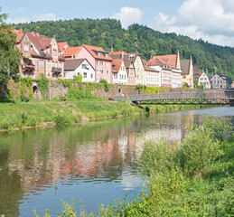 Naklejka na ściany i meble Houses reflect in the waters of the Tauber River, Wertheim, Germany.