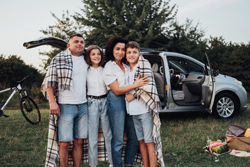 Four Members Family Having Picnic at Sunset, a Mother and Father with Two Teenage Children Enjoying Weekend Road Trip by Car