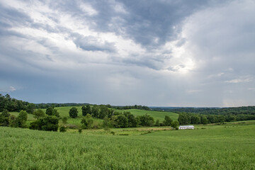 Fototapeta na wymiar Green fields and trees in a valley in Ohio's Amish country