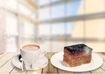 Slice of chocolate cake with coffee a white plate. Cup of coffee with cake.
