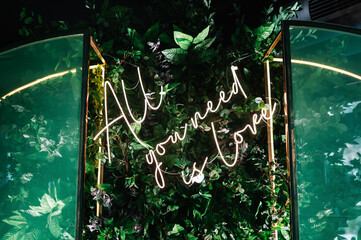 Neon sign all you need is love on a dark background with Love concept

