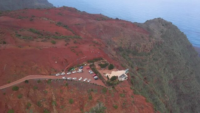 Aerial view of stunning viewpoint Mirador de Abrante with glass observation balcony above Agulo village in La Gomera island. Restaurant on red clay