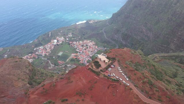 Aerial view of stunning viewpoint Mirador de Abrante with glass observation balcony above Agulo village in La Gomera island. Restaurant on red clay