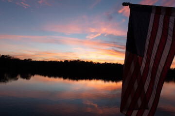 American flag at sunset over a lake